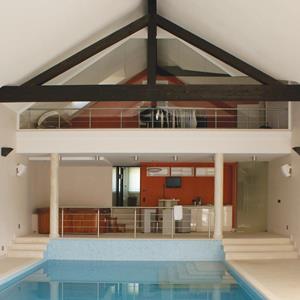 Holzelemente und offener Dachstuhl in einem Indoor-Pool